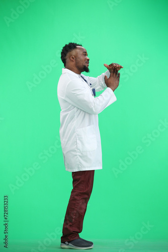 The doctor, in full height, on a green background, shows a pause sign