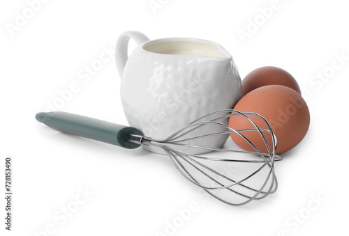 Whisk, raw eggs and jug of milk isolated on white