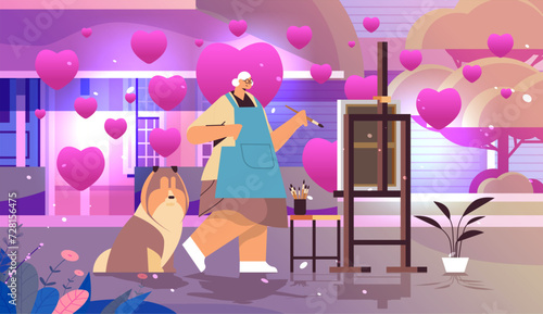 senior woman artist with dog painting picture on backyard with pink love hearts valentines day celebration concept horizontal