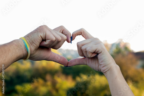 Young couple making a heart shape together. Love is all around photo