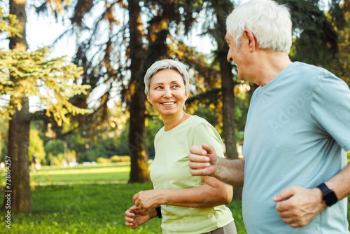 Smiling senior couple jogging in the park. Lifestyle and sport concept.