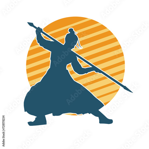 Silhouette of a martial art person in action pose with spear weapon. Silhouette of a fighter male using spear weapon in battle pose.