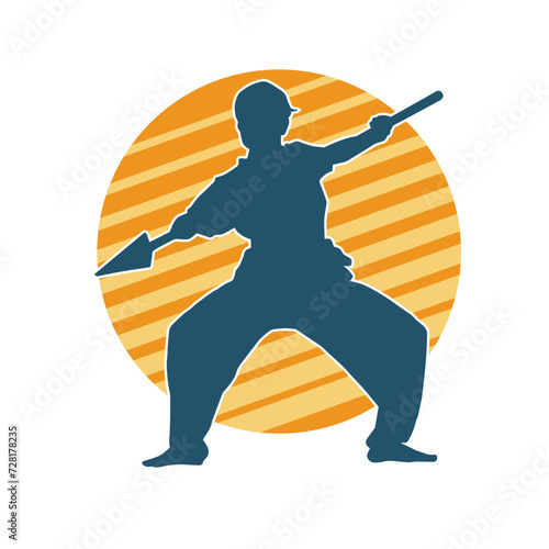 Silhouette of a wushu martial artist in action pose with a spear weapon. Silhouette of a fighter carrying a spear weapon.