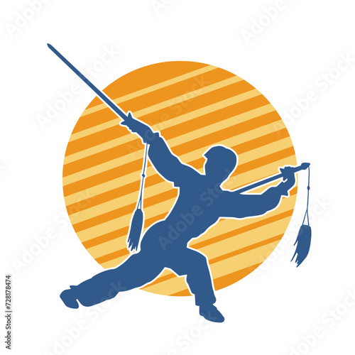 Silhouette of a kungfu or wushu martial art athlete in action pose. Silhouette of a male martial art person in pose with swords weapon.
