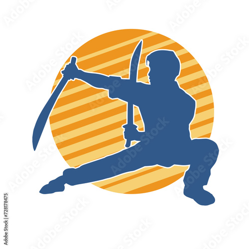 Silhouette of a kungfu or wushu martial art athlete in action pose. Silhouette of a male martial art person in pose with swords weapon.
