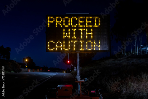 Digital sign at a freeway onramp stating Proceed With Caution