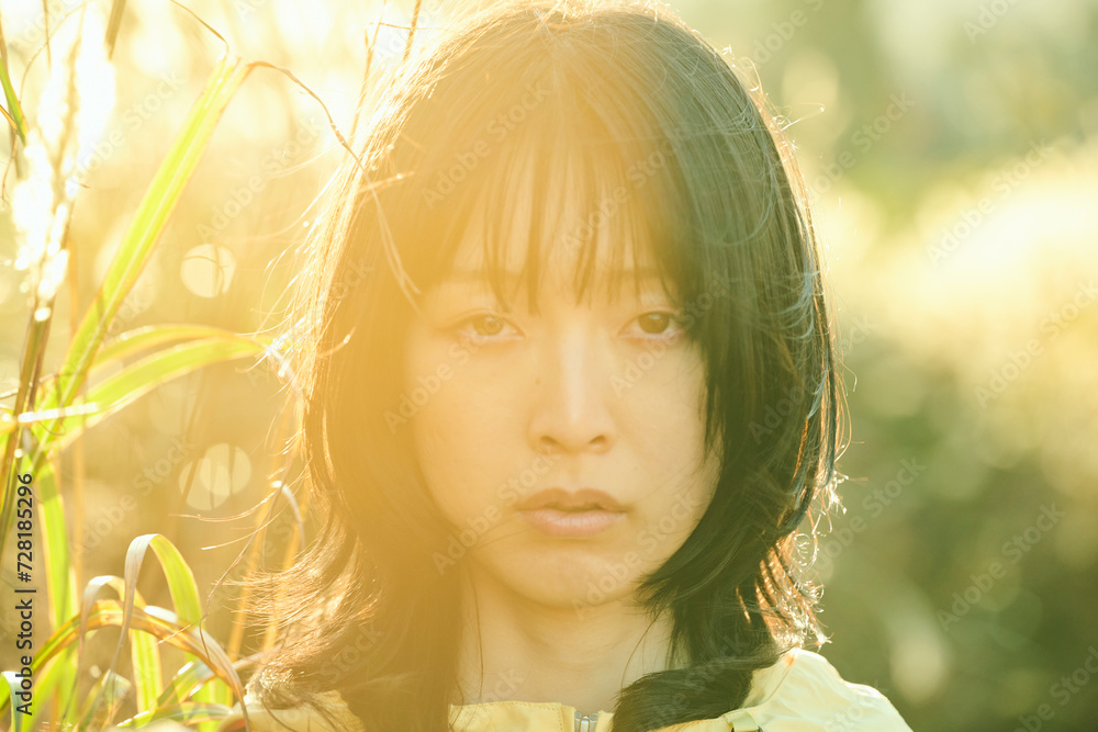 ススキ畑に立つ20代の日本人女性 ススキ畑に立つ20代の日本人女性