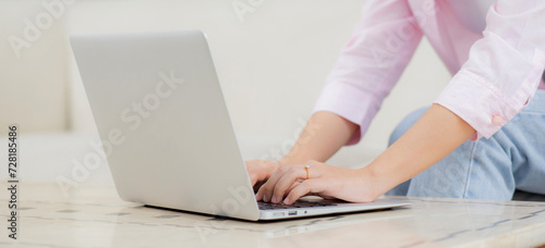 Young asian business woman work from home with laptop computer online to internet on sofa in living room  freelance is female using notebook sitting on couch with comfort and relax  lifestyle concept.