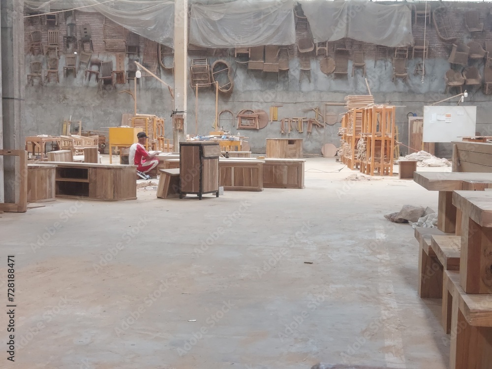 An old man is working in a furniture warehouse. An old man is working in a furniture warehouse.