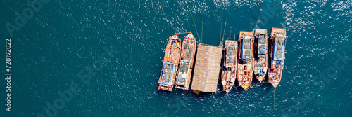 Aerial view of a cluster of fishing boats on a tranquil blue ocean, depicting a maritime or seafood concept photo