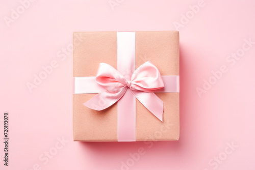 Craft gift box on a pink background, decorated with a textured bow and feathers, creating a romantic luxury atmosphere © MVProductions