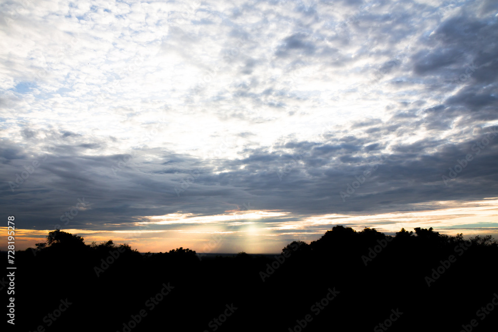 Panoramic cloudscape with the sun rays radiating from behind the cloud.Phnom Bakheng sunset view Angkor Wat, Siem Reap, Cambodia