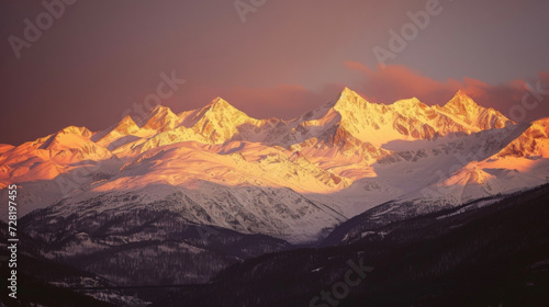 A view of snowcovered mountains in the distance their peaks glowing in the warm light of the setting sun. © Justlight