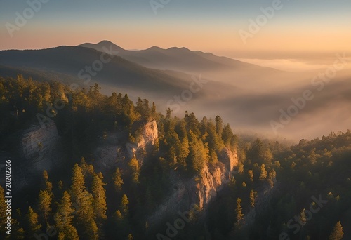 a hazy, misty sunrise over a rocky mountain range with pine trees
