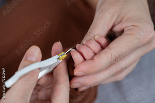 Mom cuts her newborn son s fingernails with small children s scissors.