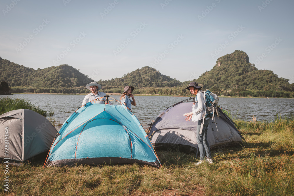 Travellers camping family under set up camp tent is summer holidays activity concept.