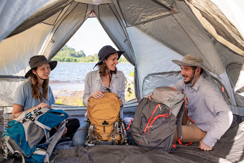 Happy family in tent with backpack is camping trip on summer hoiday. photo