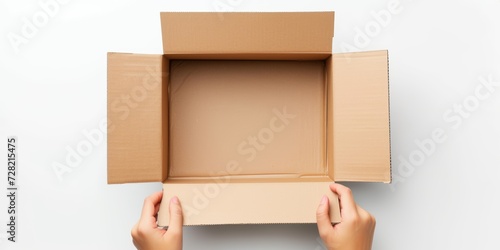 Top view to female hands opening empty brown cardboard box on white background. Mockup parcel box. Packaging, shopping, delivery concept © StockWorld