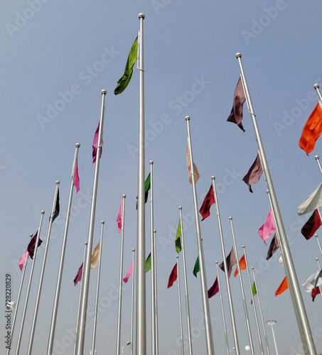 Bunch of different colored flags on the pole. Symbol of unity, equity, friendship, love, progress. Flags fluttering background for conference, camping, summit, festival, event, campaign banner poster