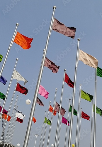 Bunch of different colored flags on the pole. Symbol of unity, equity, friendship, love, progress. Flags fluttering background for conference, camping, summit, festival, event, campaign banner poster