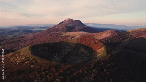 drone shot flying over puy pariou and revealing the Puy de Dome in the background at sunrise, Clermont Ferrand, Auvergne, France