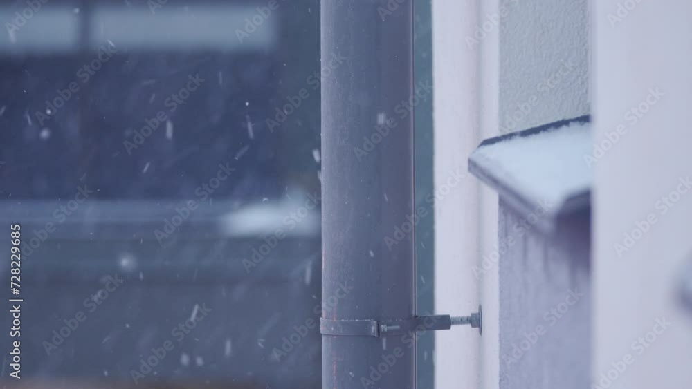 snow falls outside the apartment window of a multi-storey residential building in winter snow falls outside the apartment window of a multi-storey residential building in winter