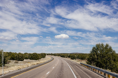 Beautiful blue sky with fluffy clouds over the highway. Scenic road in Arizona, USA on a sunny summer day. 40 hwy, 10 hwy in Arizona, USA - 17 April 2020