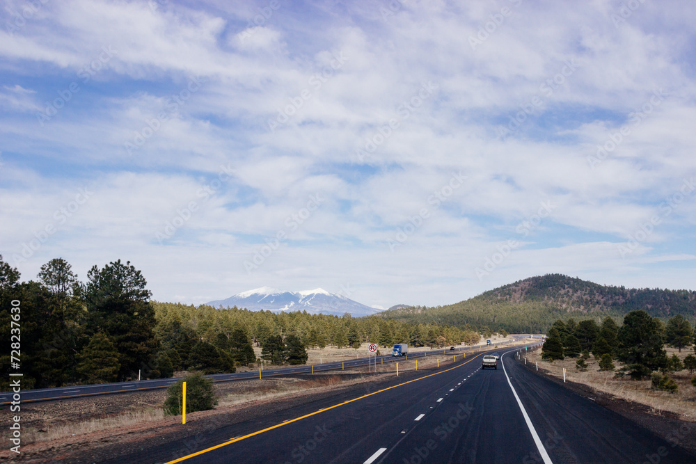 Beautiful blue sky with fluffy clouds over the highway. Scenic road in Arizona, USA on a sunny summer day. 40 hwy, 10 hwy in Arizona, USA - 17 April 2020