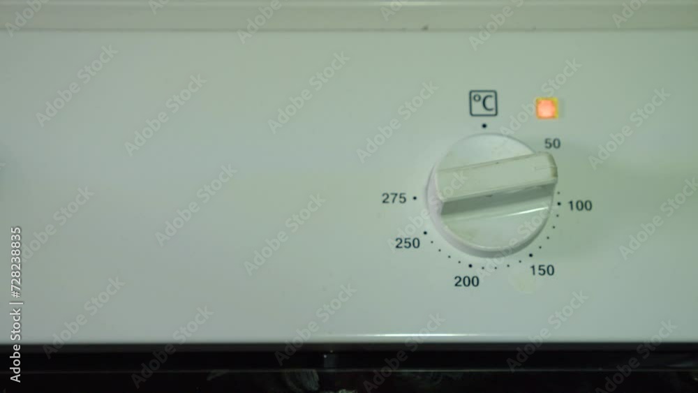 Oven temperature control knob is turned to 200 degrees celsius by hand Oven temperature control knob is turned to 200 degrees celsius by hand