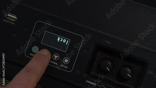 Close-up finger presses buttons on stage lighting Fresnel controller photo