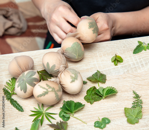 A girl cooks eggs in tights with leaves. Easter