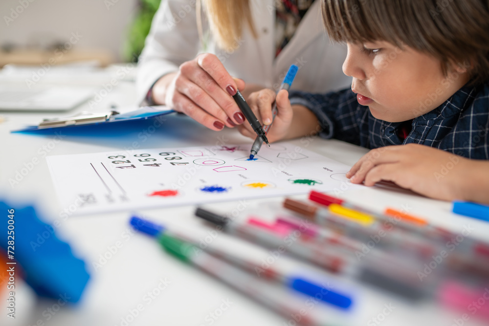 Toddler solving a psychology test with the guidance of a pediatric psychologist Toddler solving a psychology test with the guidance of a pediatric psychologist