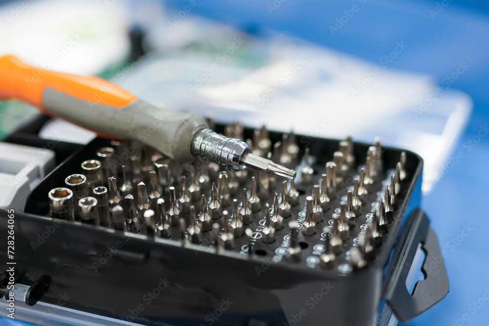 Close up view of screw driver with different drive bits.