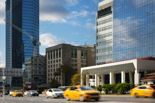 Cars quickly rush along the road against the backdrop of skyscrapers in a prestigious area of the city.