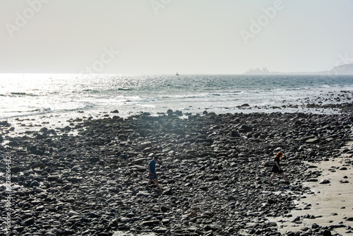 Young girl and a boy on a stony beach by the sea