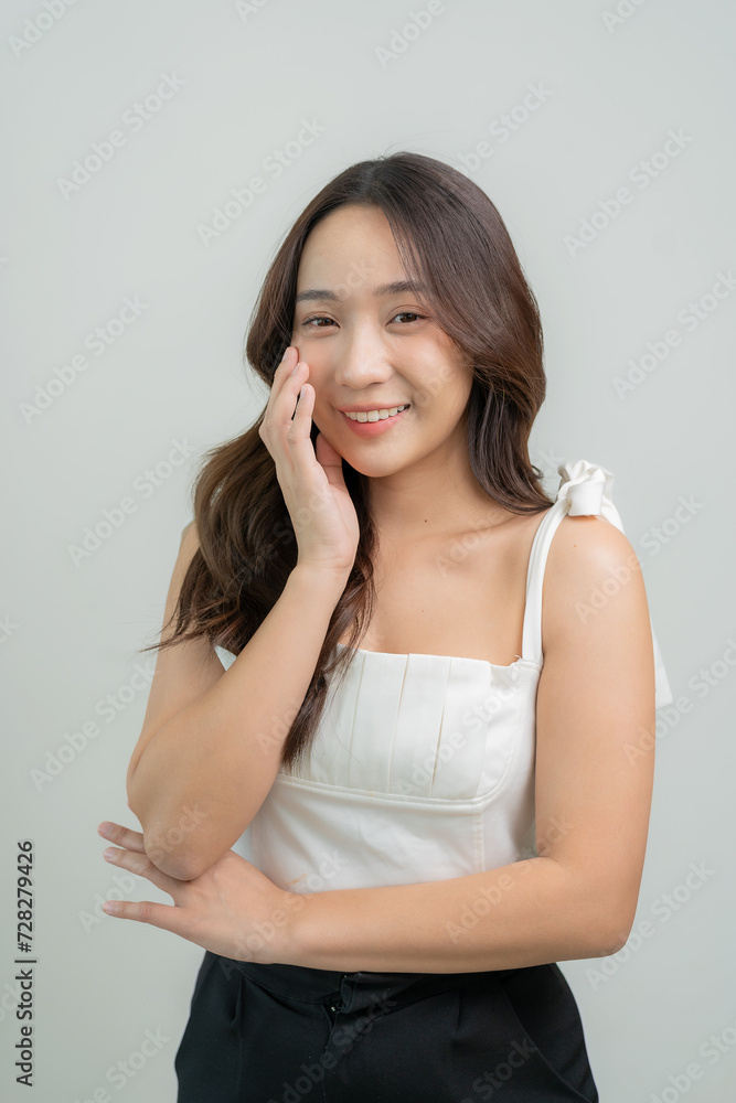 Portrait of a beautiful young Asian girl applying dry powder Makeup with cosmetic cushion on her face with mascara placed on eyelashes on white background, makeup concept Portrait of a beautiful young Asian girl applying dry powder Makeup with cosmetic cushion on her face with mascara placed on eyelashes on white background, makeup concept