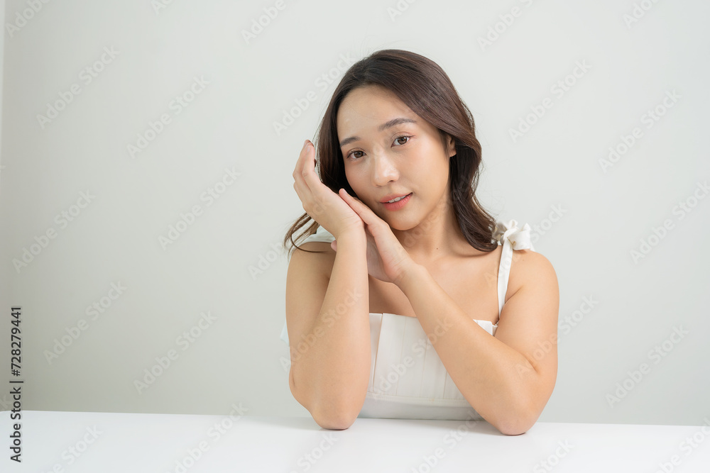 Portrait of a beautiful young Asian girl applying dry powder Makeup with cosmetic cushion on her face with mascara placed on eyelashes on white background, makeup concept Portrait of a beautiful young Asian girl applying dry powder Makeup with cosmetic cushion on her face with mascara placed on eyelashes on white background, makeup concept