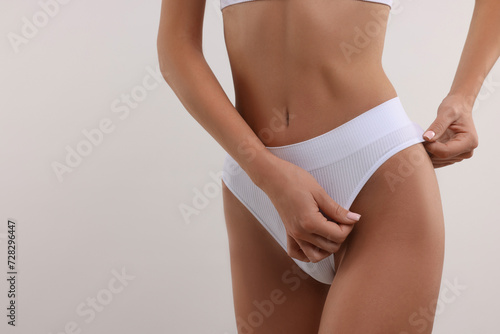 Young woman in stylish bikini on white background, closeup. Space for text