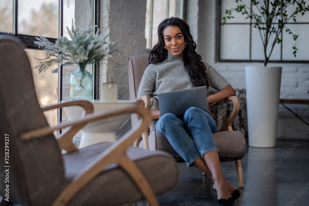 An African American woman sitting in a café and using a laptop and working An African American woman sitting in a café and using a laptop and working