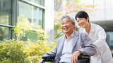 シニアと介護、車椅子に乗る日本人男性と介護士の女性
