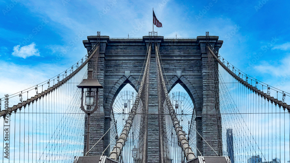 Obraz premium The famous and wonderful Brooklyn Bridge linking the boroughs of Manhattan and Brooklyn in New York City (USA), a day with blue sky and lots of clouds.