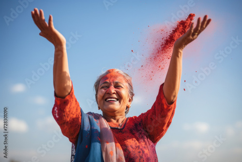 Energetic woman scattering red Holi color in sunlight © Photocreo Bednarek