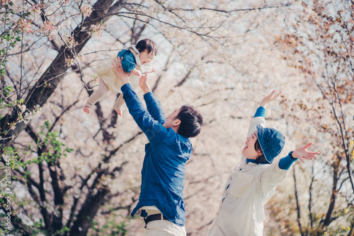 Fotografie 桜と高い高いされる赤ちゃんと家族