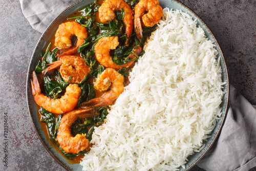 Spinach Shrimp Curry or Jheenga Palak cooked in a spinach, cream, spices, tomato and ginger served with rice closeup on the plate on the table. Horizontal top view from above photo