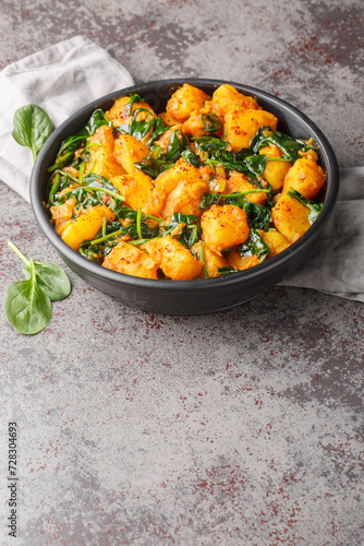 Aloo Palak sabzi Spinach Potatoes curry served in a bowl closeup on the table. Vertical