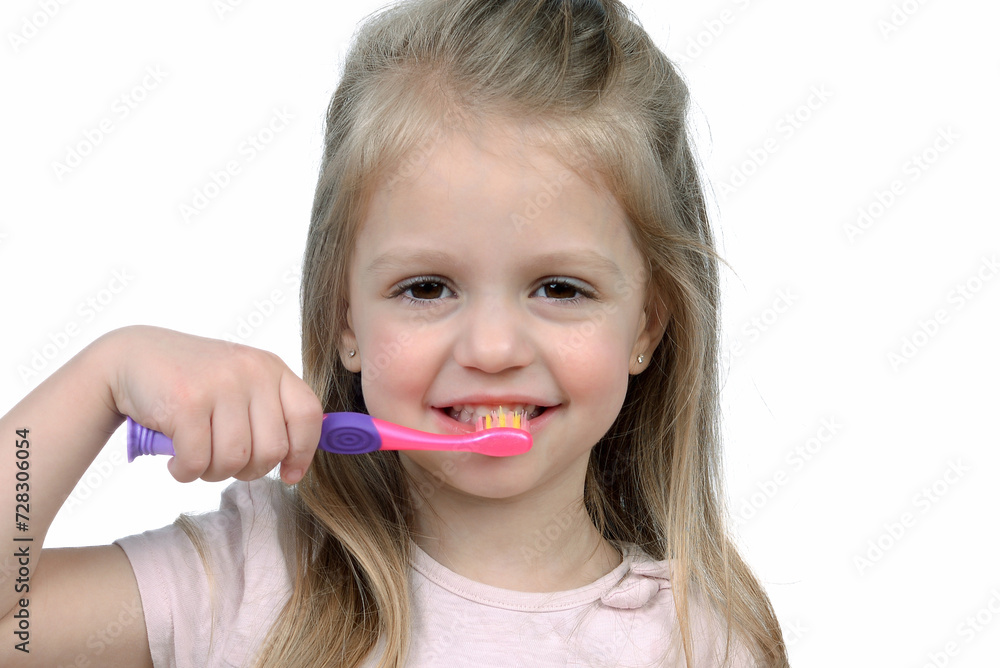 Closeup portrait of a little girl on a white background. A child holds a toothbrush. The concept of daily hygiene. Copy space Closeup portrait of a little girl on a white background. A child holds a toothbrush. The concept of daily hygiene. Copy space
