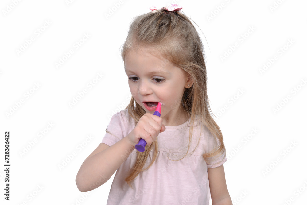 Closeup portrait of a little girl on a white background. A child holds a toothbrush. The concept of daily hygiene. Copy space Closeup portrait of a little girl on a white background. A child holds a toothbrush. The concept of daily hygiene. Copy space