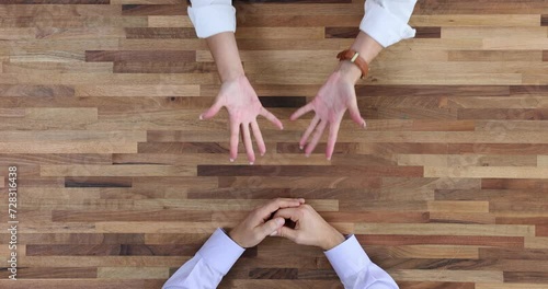 Male hands nervously move their fingers on table, top view photo
