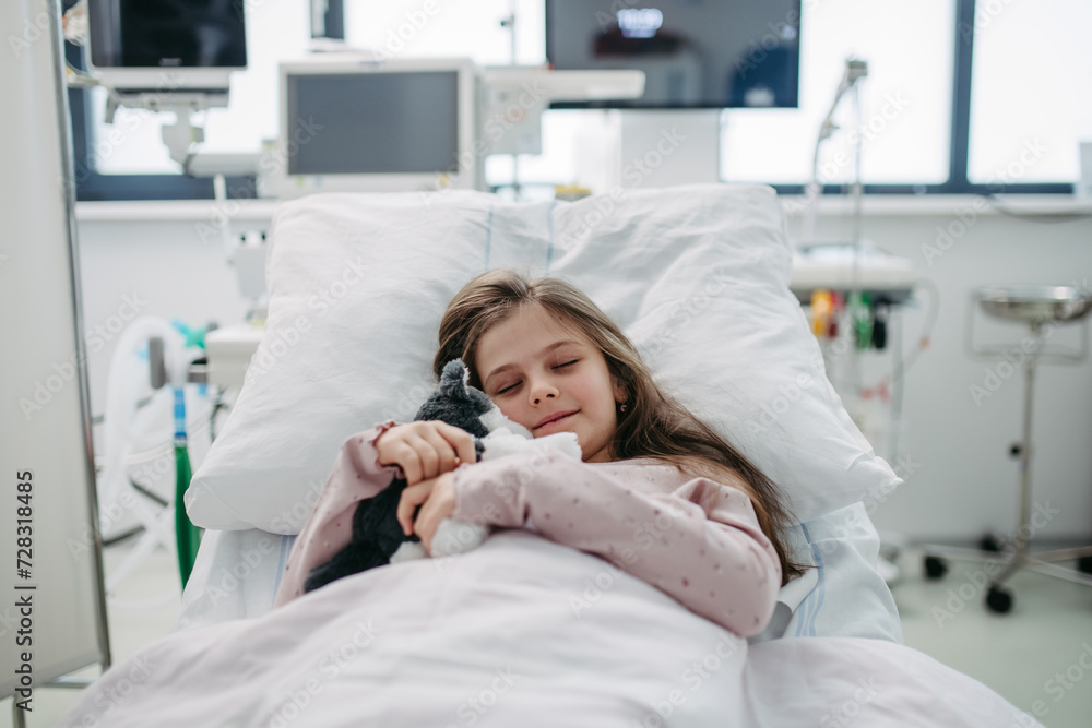 Little girl patient lying in hospital bed. Children in intensive care unit in hospital sleeping. Little girl patient lying in hospital bed. Children in intensive care unit in hospital sleeping.