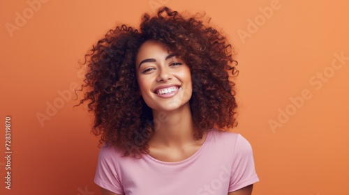 Smiling woman with curly hair on orange background. Generative AI. © serg3d